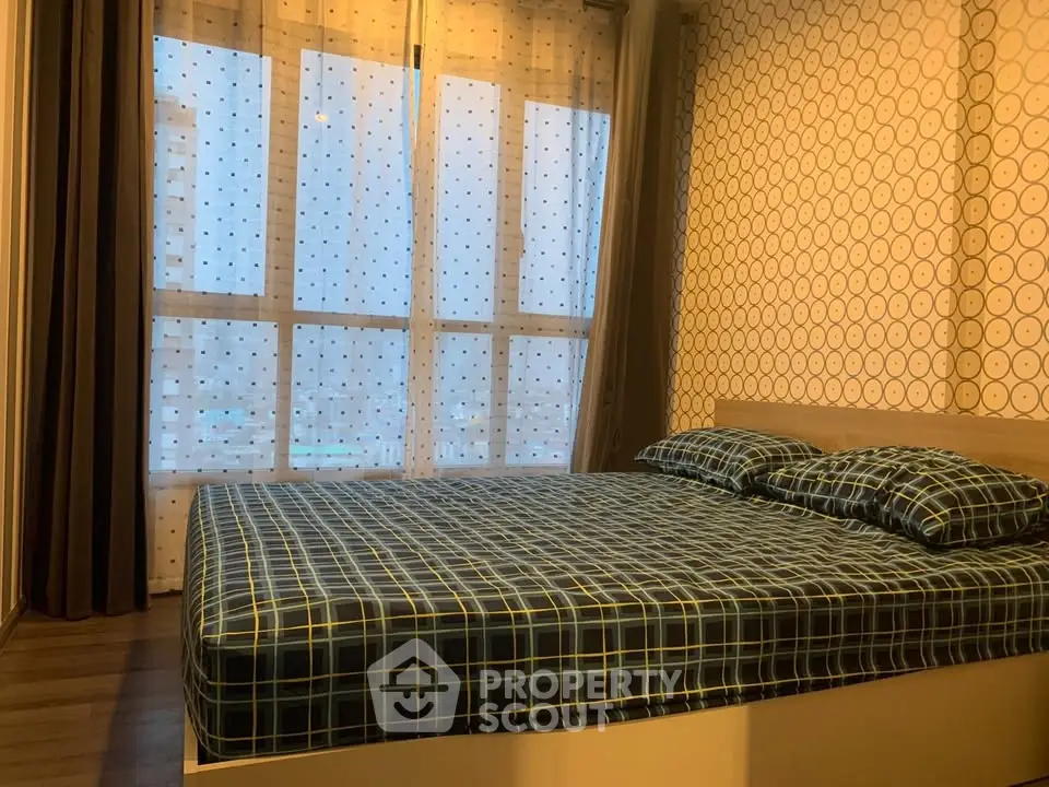 Cozy bedroom with large window and stylish decor in modern apartment.