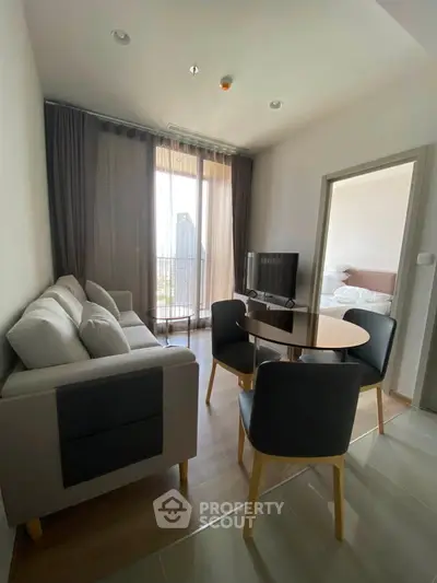 Modern living room with cozy seating and natural light in a stylish apartment.