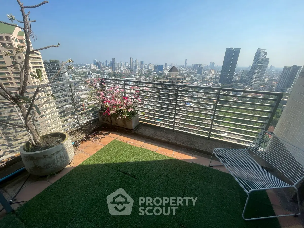 Stunning cityscape view from a high-rise balcony with lush greenery and modern seating.