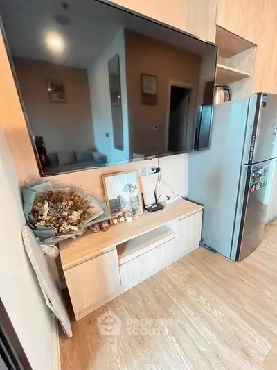 Modern living room with sleek TV setup and stylish wooden cabinet, featuring a cozy and inviting atmosphere.
