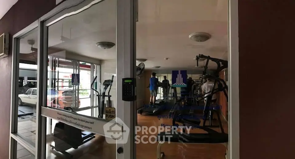 Modern gym with exercise equipment in a residential building, featuring treadmills and weight machines.