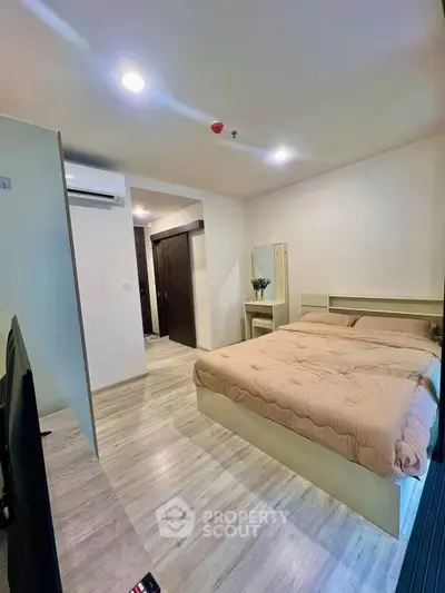 Modern bedroom with cozy bed and stylish decor in a contemporary apartment.
