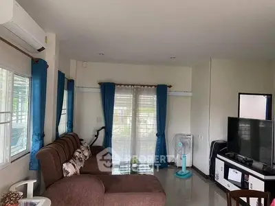 Cozy living room with brown sofa, TV, and blue curtains in a modern home.