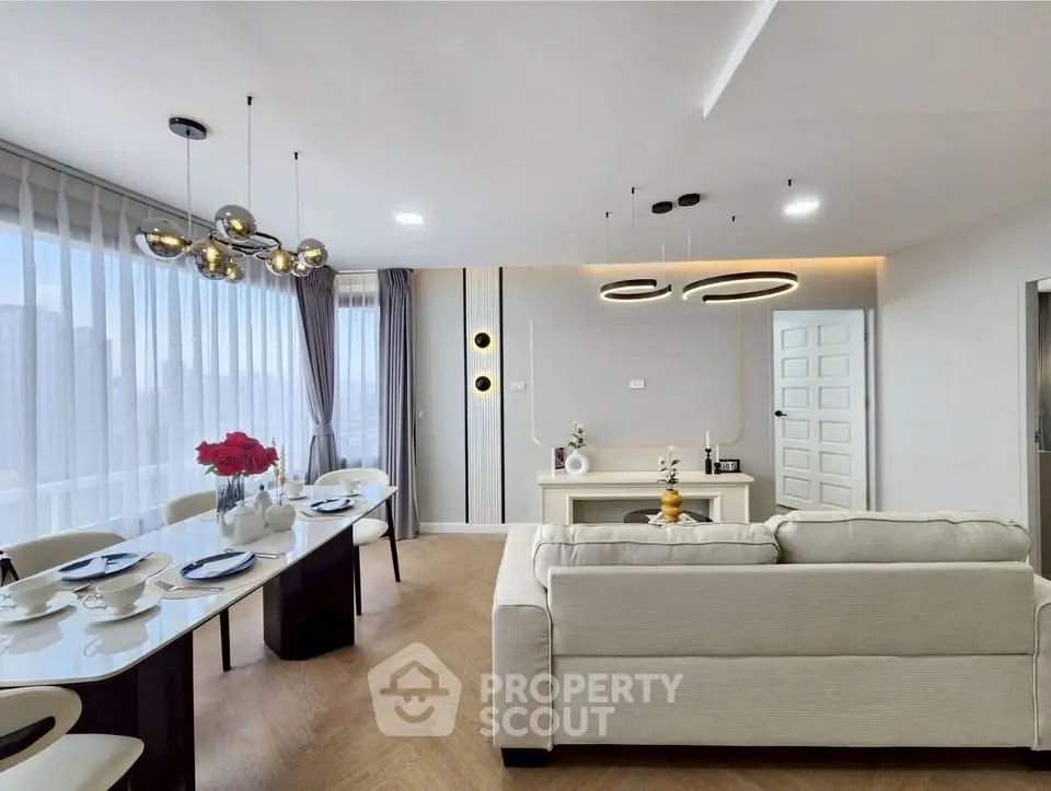 Modern open-plan living and dining area with elegant decor and large windows.