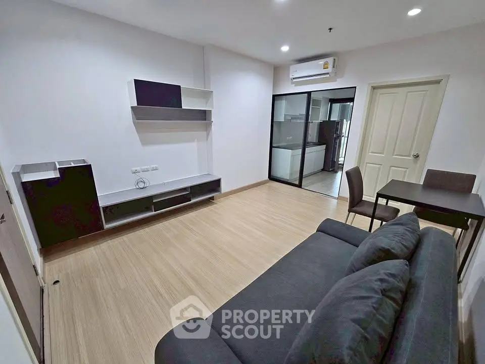 Modern living room with sleek furniture and open layout, featuring a cozy sofa and dining area.