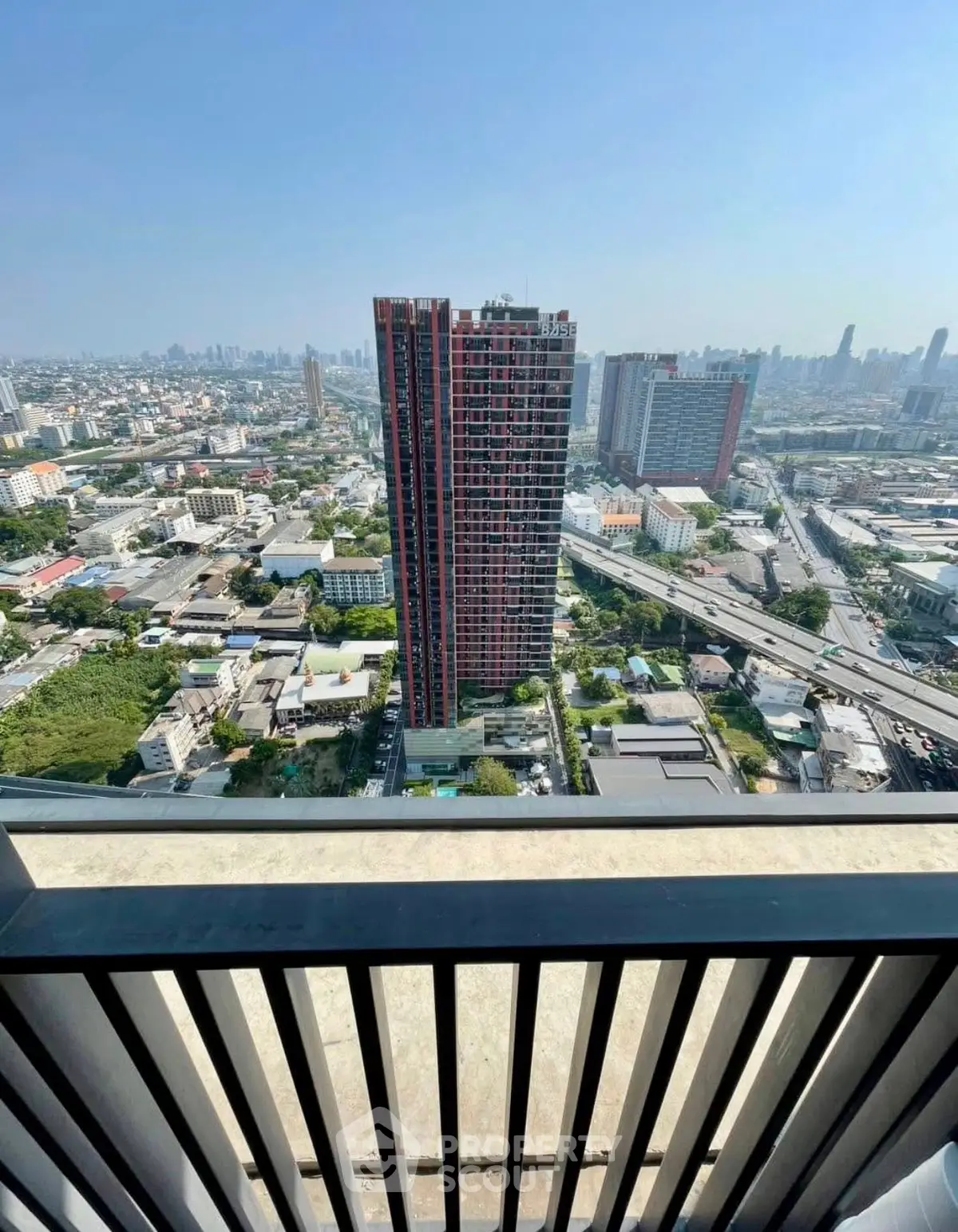 Stunning cityscape view from a high-rise balcony overlooking urban skyline and modern architecture.
