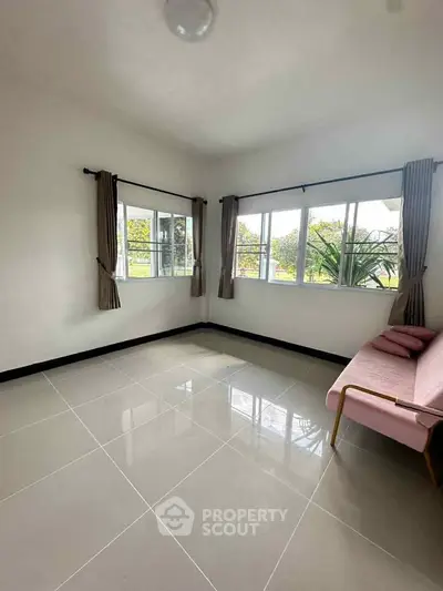 Bright and airy living room with large windows and modern tile flooring.