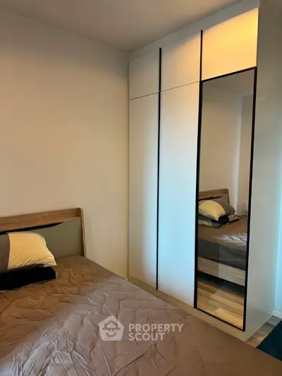 Cozy bedroom with modern wardrobe and stylish bedding