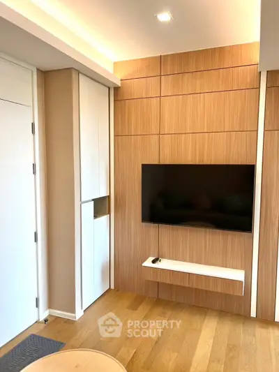 Modern living room with sleek wooden paneling and wall-mounted TV