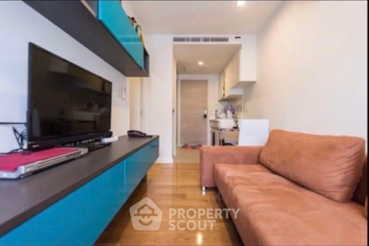 Modern living room with sleek blue cabinetry and cozy brown sofa