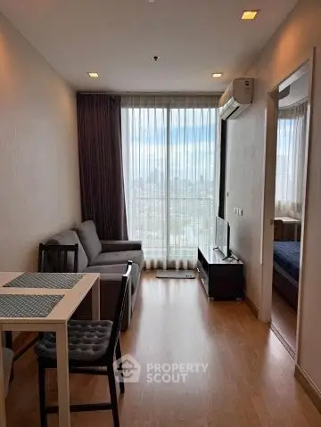Modern living room with city view, featuring sleek furniture and natural light.