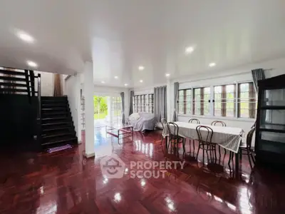 Spacious living room with elegant wooden flooring and large windows offering natural light.