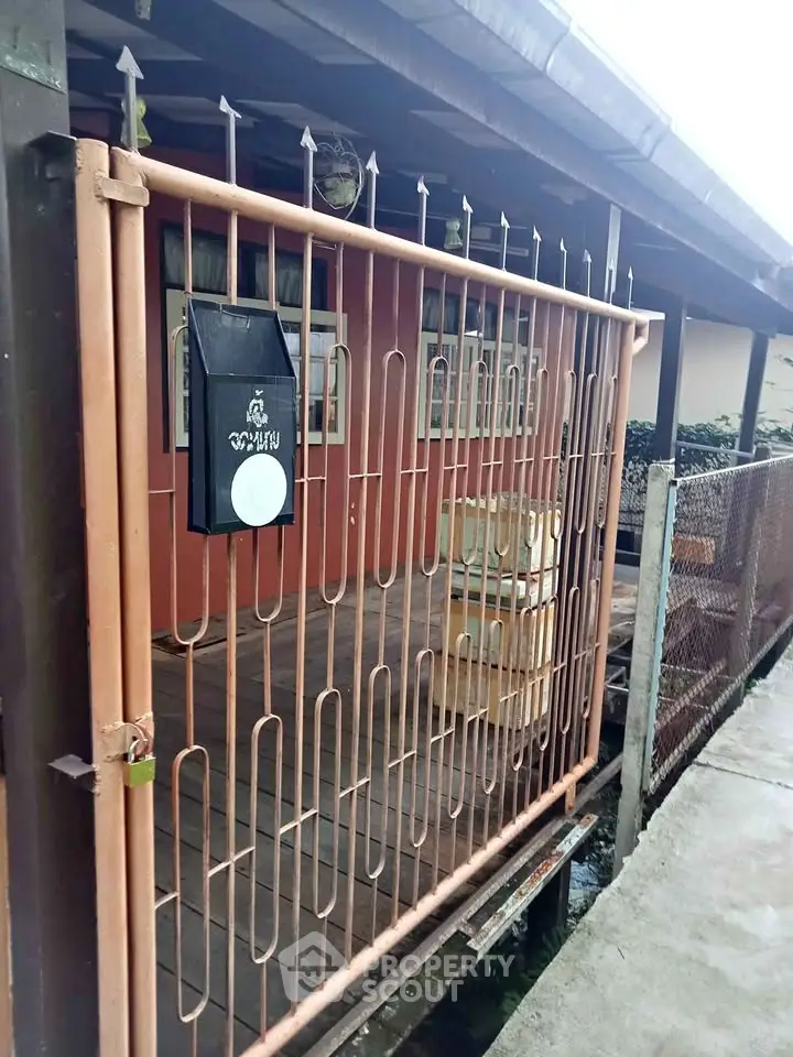 Charming rustic exterior with gated entrance and wooden deck, perfect for cozy living.