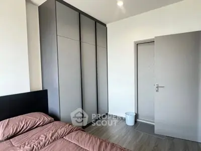 Modern bedroom with sleek wardrobe and cozy bed in contemporary apartment.