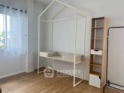 Minimalist bedroom with unique open-frame bed and wooden flooring