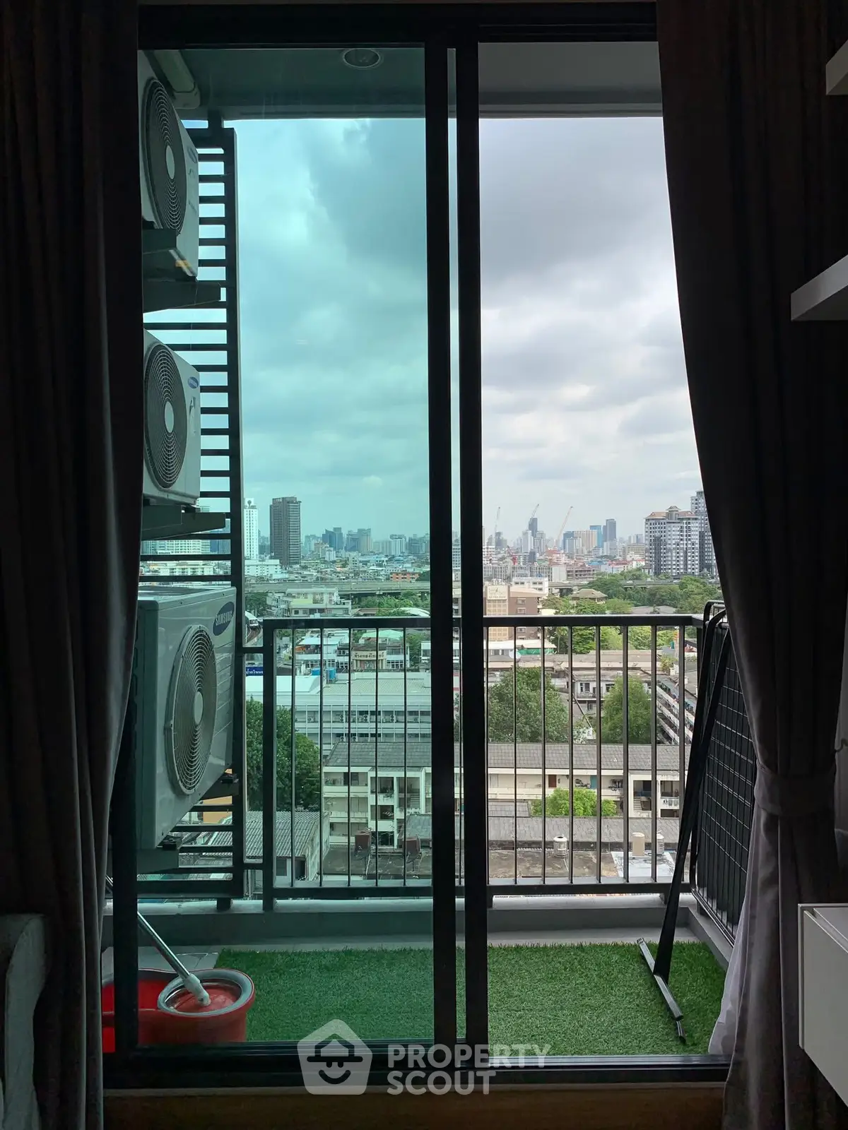 Stunning city view from a modern balcony with air conditioning units.