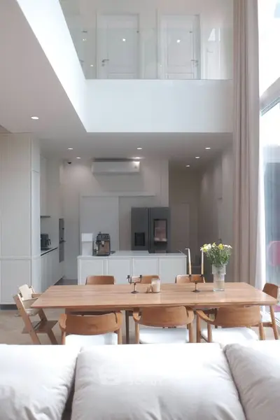 Modern open-plan kitchen and dining area with high ceilings and natural light.