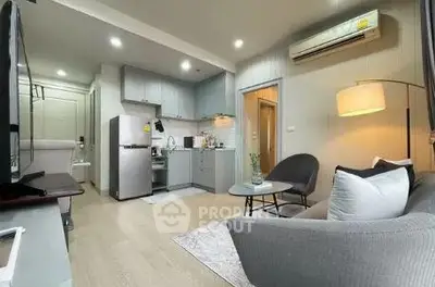 Modern living room with open kitchen, featuring sleek furniture and contemporary design.