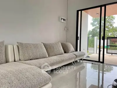 Modern living room with sleek sofa and sliding glass doors opening to a patio.