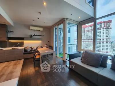 Modern living room with large windows and city view, featuring stylish furniture and open layout.