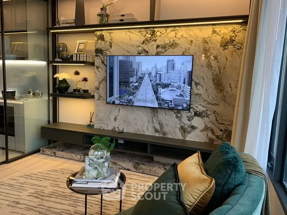 Luxurious living room with marble accent wall and modern decor, featuring a large TV and elegant shelving.