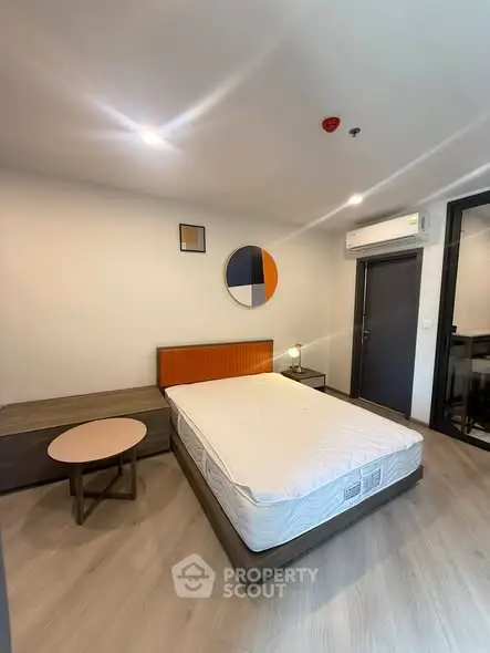 Modern bedroom with stylish decor and air conditioning in a contemporary apartment.