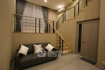 Modern living room with stylish staircase and cozy sofa in elegant apartment