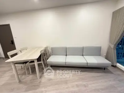 Modern living room with sleek sofa and dining table in minimalist design.