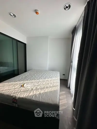 Modern bedroom with large window and minimalist design, featuring a comfortable bed and sleek curtains.