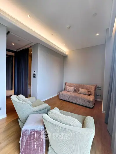 Spacious living room with modern furniture and elegant lighting, perfect for relaxation and entertainment.