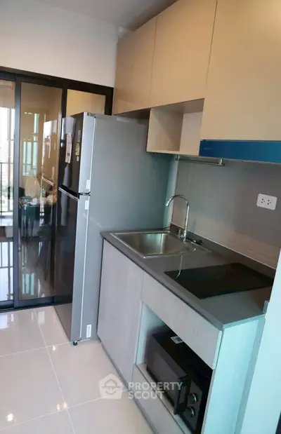 Modern kitchen with sleek cabinetry and stainless steel appliances in a stylish apartment.