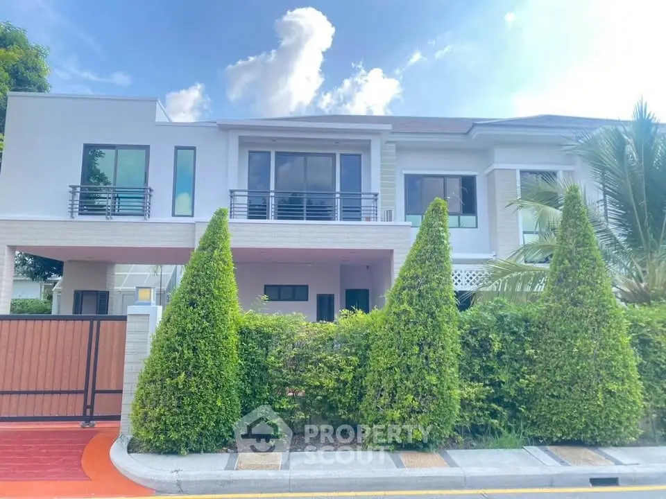 Stunning modern two-story house with lush greenery and sleek design.