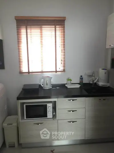 Modern kitchen with microwave, kettle, and sleek cabinetry