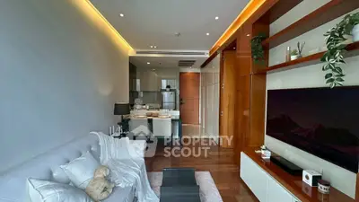 Modern living room with open kitchen, sleek design and cozy ambiance.