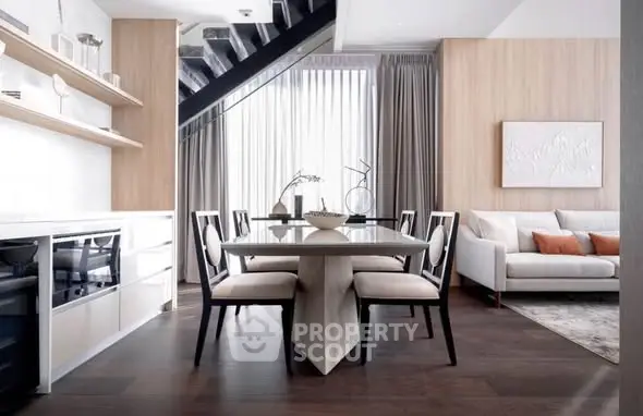 Modern dining area with elegant decor and natural light in a stylish open-plan living space.