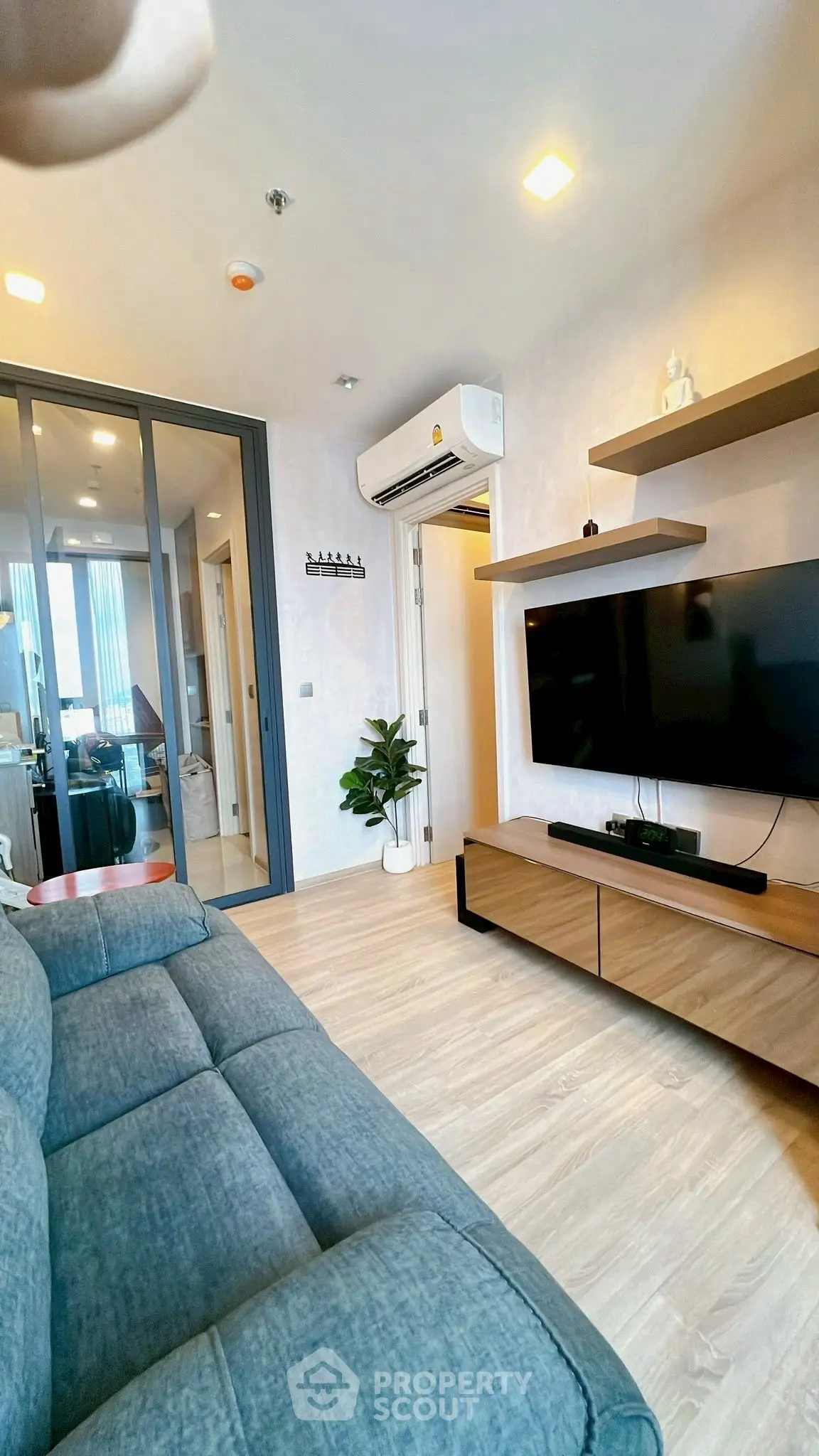 Modern living room with sleek design, featuring a wall-mounted TV and stylish furniture.