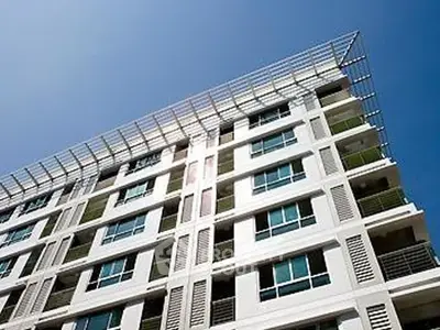 Modern apartment building with sleek design and large windows under a clear blue sky.