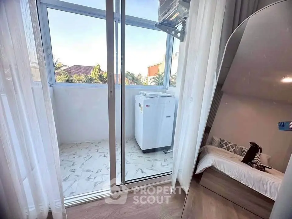 Charming balcony with washing machine and cozy bedroom view