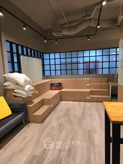 Modern multi-level living space with wooden flooring and ample natural light.