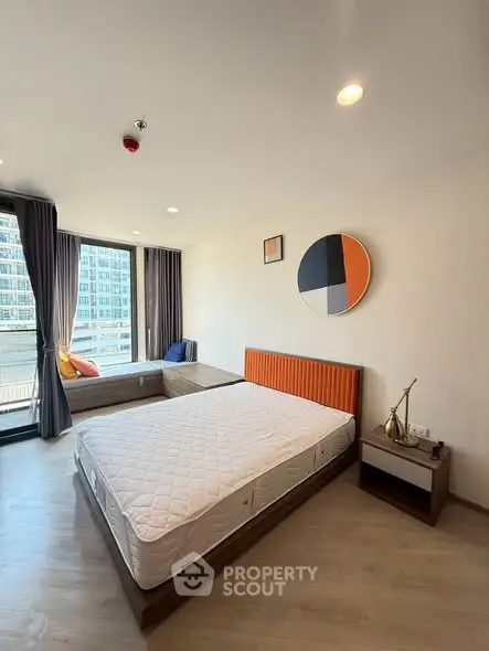 Modern bedroom with large windows and stylish decor in a high-rise apartment.