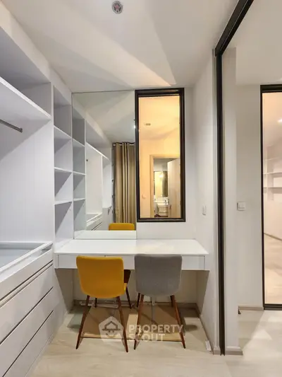 Modern study area with sleek desk and colorful chairs in a stylish apartment