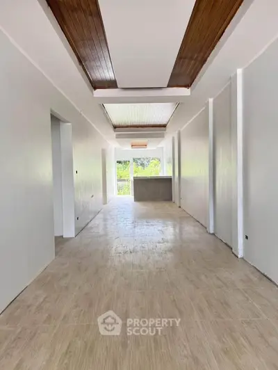 Spacious modern hallway with wooden ceiling accents and bright natural light.