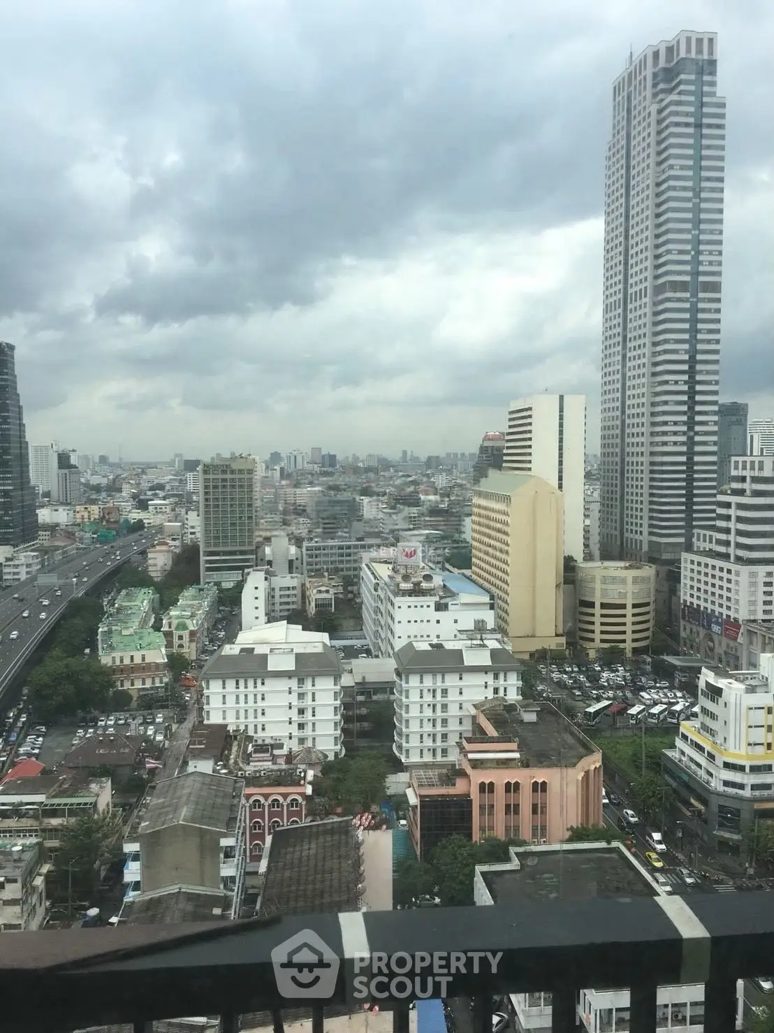Stunning cityscape view from a high-rise balcony showcasing urban skyline and towering skyscrapers.