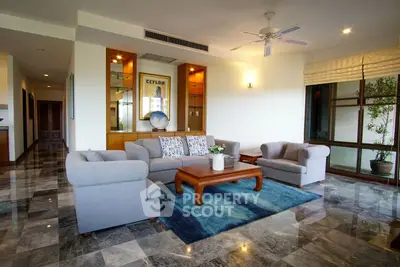 Spacious living room with elegant furniture and large windows in modern apartment.