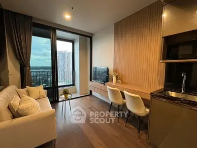 Modern living room with city view, cozy seating, and sleek kitchen area