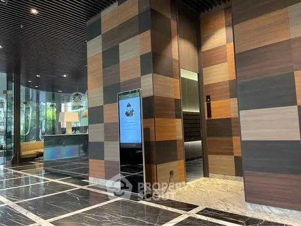 Luxurious modern building entrance with sleek design and elegant marble flooring.