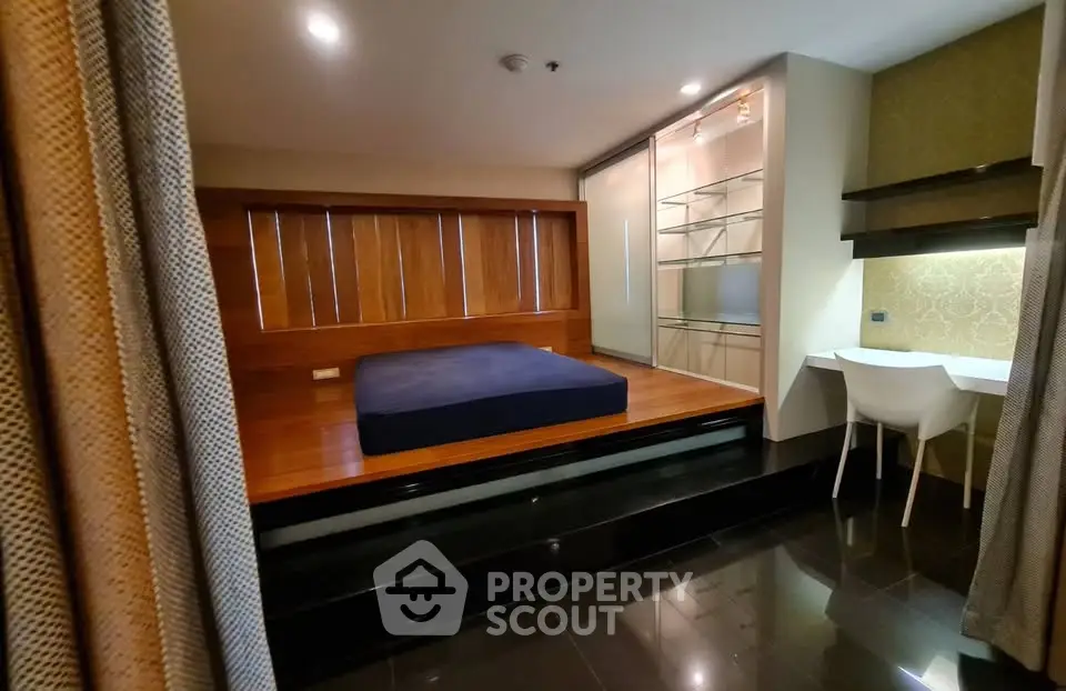Modern bedroom with elevated platform bed and sleek workspace