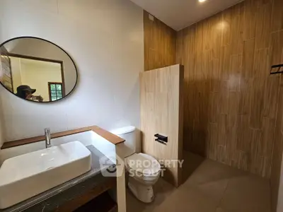 Modern bathroom with wooden accents and round mirror