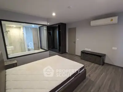 Modern bedroom with ensuite bathroom and air conditioning in stylish apartment.