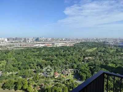 Stunning panoramic city view from high-rise balcony overlooking lush greenery and urban skyline.